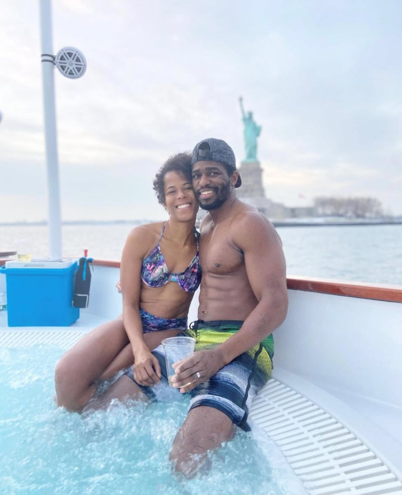 Man and woman in hot tub boat in front of the statue of liberty