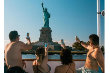 people on a hot tub boat in NYC looking at the statue of liberty