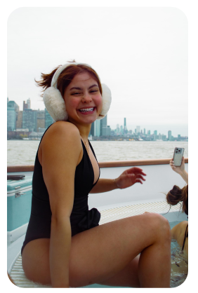 a woman sitting next to a body of water