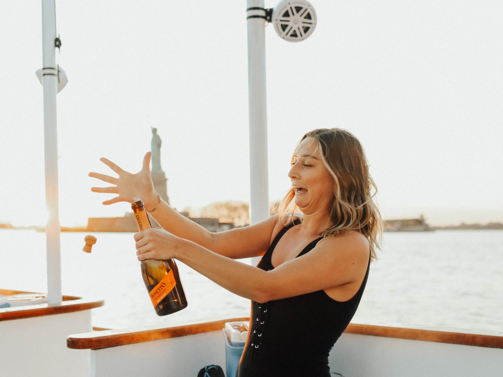 a woman popping champagne in NYC hot tub boat