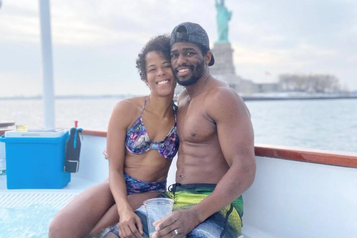 Man and woman in hot tub boat in front of the statue of liberty