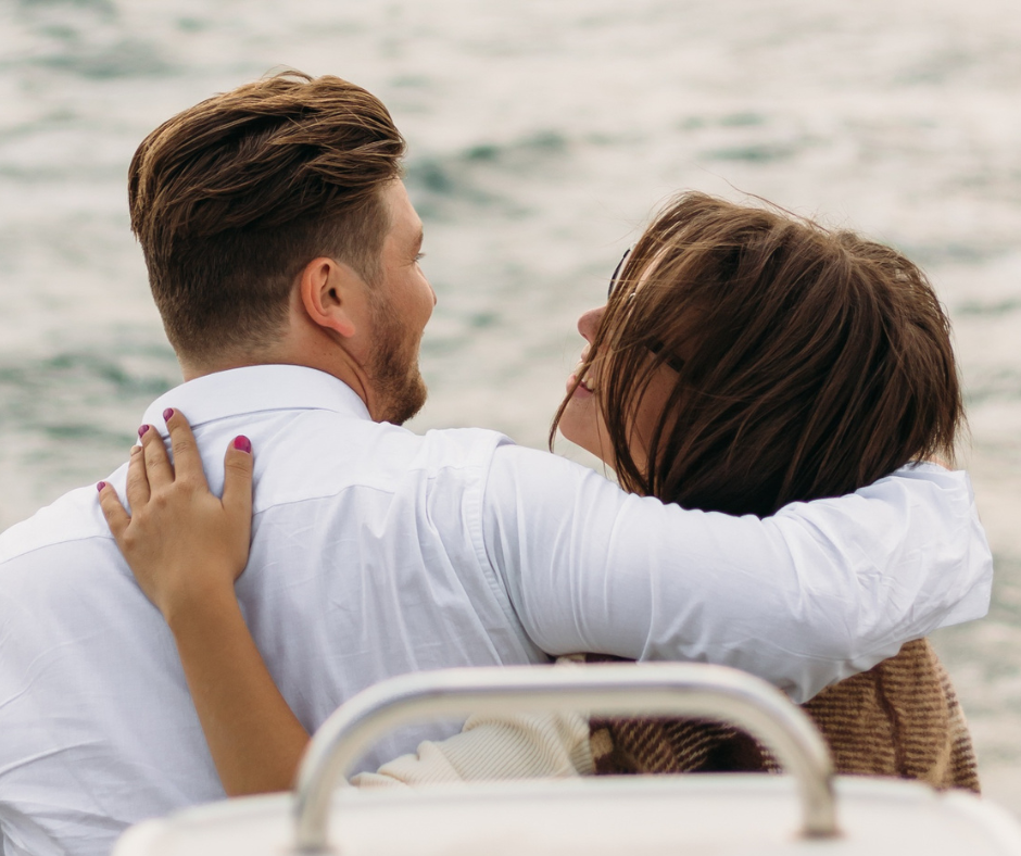 a man and a woman looking at the water