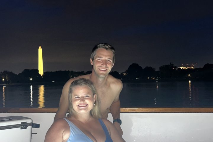 engaged couple in hot tub boat viewing Lincoln Memorial at night
