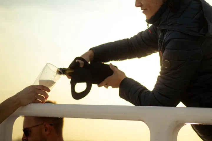 person pouring mimosas on a hot tub boat in NYC